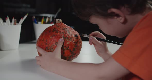 One Boy Decorating and Painting Pumpkin for Halloween