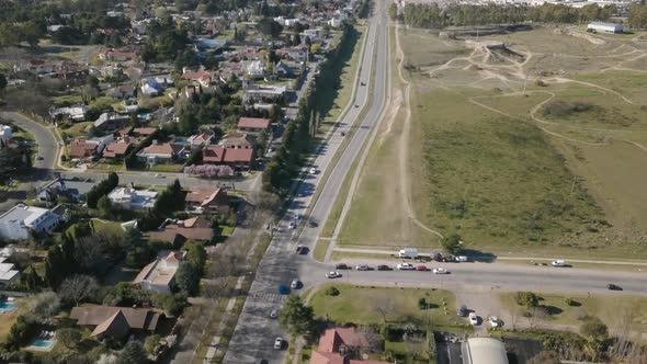 Aerial Drone shot of highway with cars going through and suburbs on side