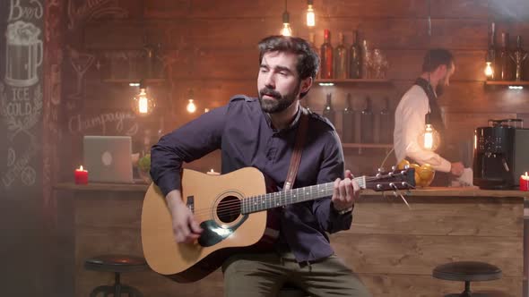 Male Musician Performing a Song on His Guitar in a Small Pub