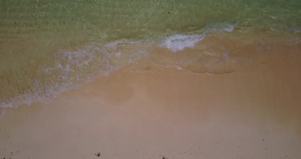 Wide flying tourism shot of a white paradise beach and turquoise sea background in colourful 4K