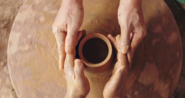 A Potters Hands Guiding A Tourist Hands To Help Him To Work