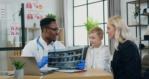 Doctor is Satisfied from X-ray Image of His Boy-Patient and Giving High Five Each other