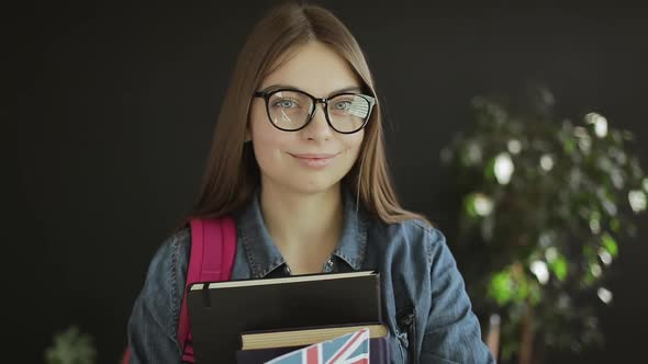 British Student Holding Books and a Flag