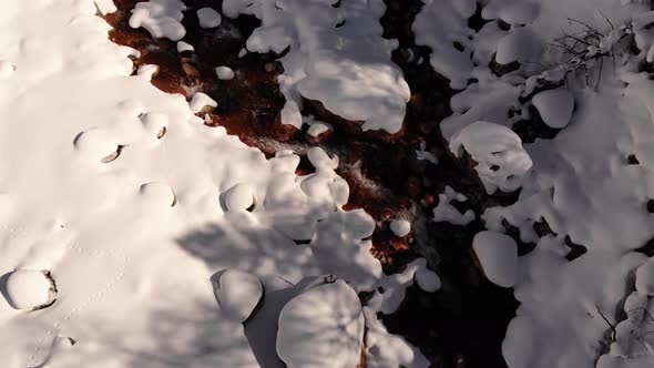 Aerial Slow Motion Over Snowcovered Coast Mountain River Stream