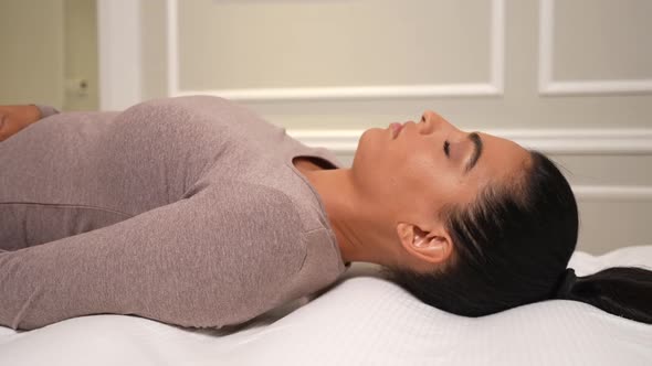 Woman Lying on Her Back Without a Pillow