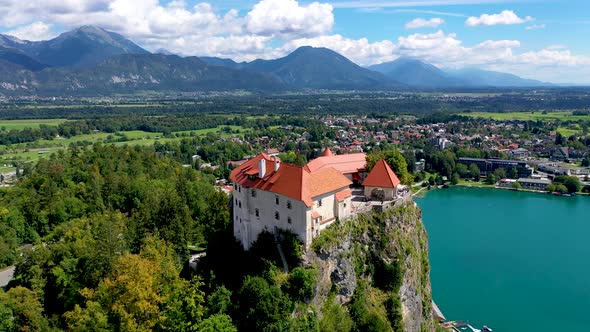 Cinematic side view of fairy tale castle surrounded by lake and mountains