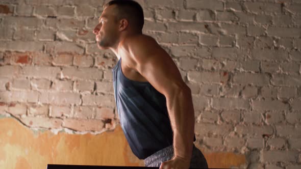 Man Doing Triceps Dip on Parallel Bars in Gym