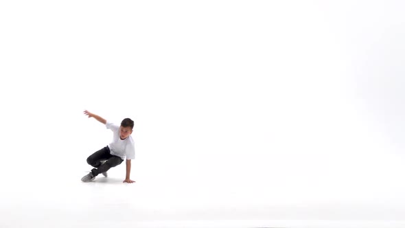 Little Boy Is Dancing a Modern Dance on the White Background in Black Leather Jackets and Jeans