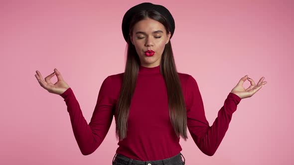 Calm girl in red relaxing, meditating. Woman calms down, breathes deeply with mudra om