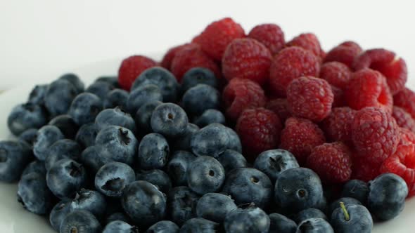 Assorted fruits and berries on a white background rotation 360. Summer fruit raspberry blueberry