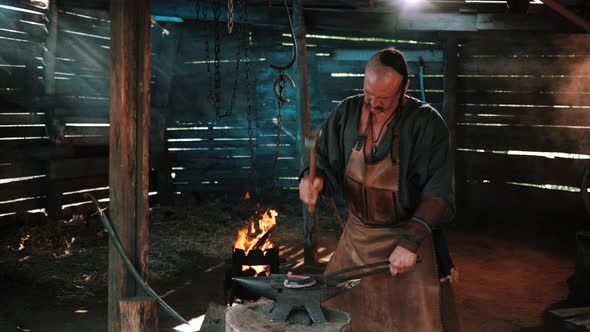 Blacksmith in the Forge Forges a Horseshoe