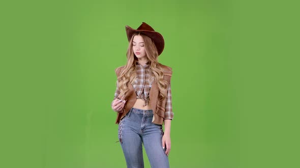 Girl in the Shape of a Cowboy Is Waiting for Her Friends and Looks at Her Watch. Green Screen
