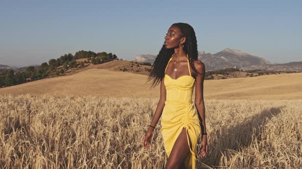 Woman Walking Along Open Fields on a Summer Day with Sunny Skies in Background