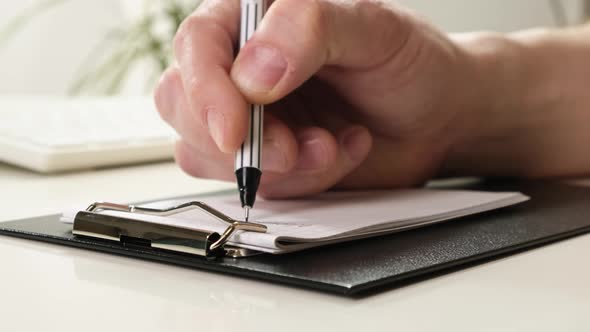 Hand Lay on the Table, Holding a Pencil and Writing. Close-up.