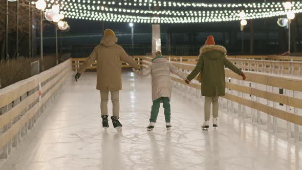 Family Of Three Ice-Skating