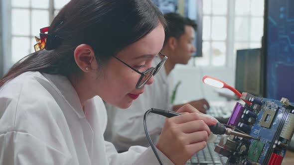 Asian Female Engineer Does Computer Motherboard Soldering. Scientists Design Industrial Pcb