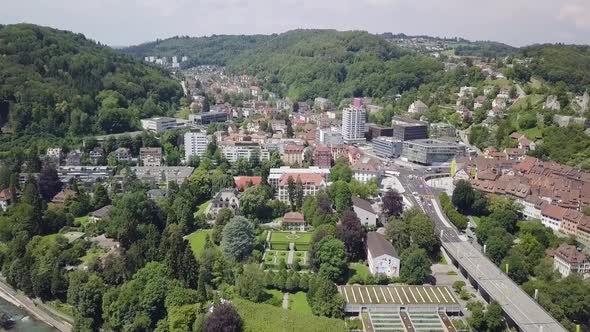 Drone flight over the city called Baden in Switzerland. The city is covered in a lot of trees.