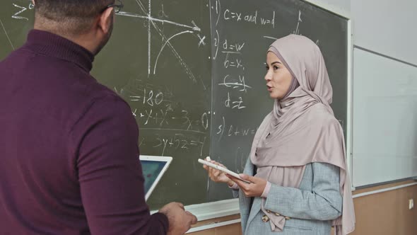 Muslim Female Student Solving Geometry Problem at Blackboard