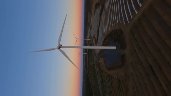 Vertical Dynamic Fpv Shot of White Operative Wind Turbine While Beautiful Sunset