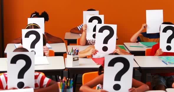 School kids covering their face with question mark sign