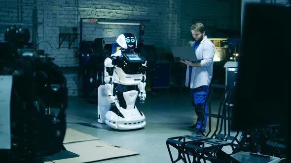 Male Specialist is Observing a Cyborg in the Workshop