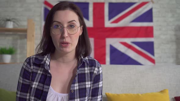 Young Woman Blogger in Shirt on the Background of the Flag UK Entry Video Close Up