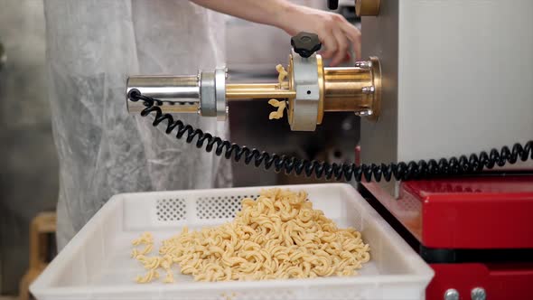 Tortiglioni Cazarece Spaghetti Pasta Falling From a Spout As They Travel Along the Production Line