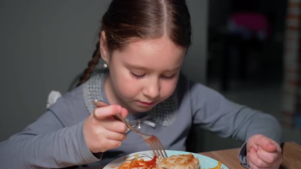 The child eats pasta with a fresh salad of tomato, pepper and round cheese. 4K