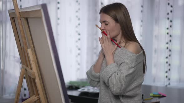 Sad Beautiful Painter Making Mistake Painting on Canvas Standing at Easel Shaking Head