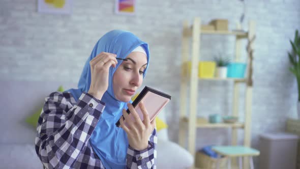 Beautiful Young Muslim Woman Makes Makeup Cares for Skin Looks in Mirror