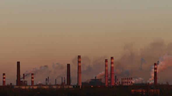 Chemical factory. Many chimneys emit toxic substances at sunset. Ecological problem.
