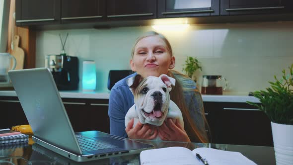 Happy Woman with a Bulldog Looking To the Camera and Smiling