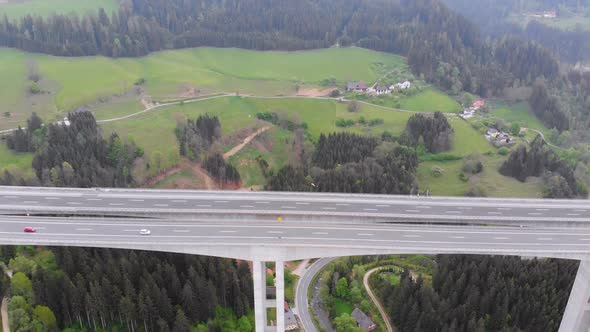 Aerial View of the Highway Viaduct on Concrete Pillars with Traffic in Mountains