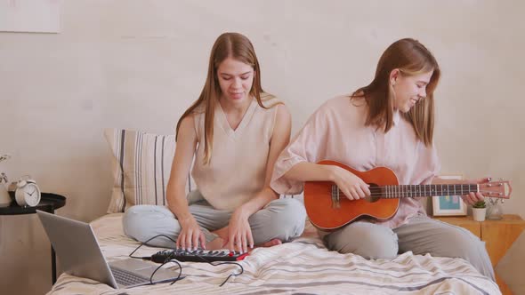 Happy Twin Sisters Playing Musical Instruments