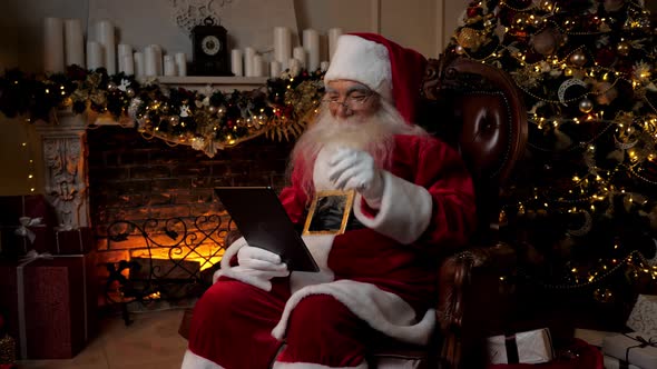 Modern Smiling Santa Claus Greets Talks to Children Online Tablet Video Call