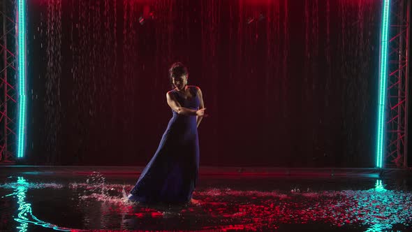 Beautiful Sexy Woman Dancing Flamenco Elements in a Dark Studio Under the Rain. During the Dance