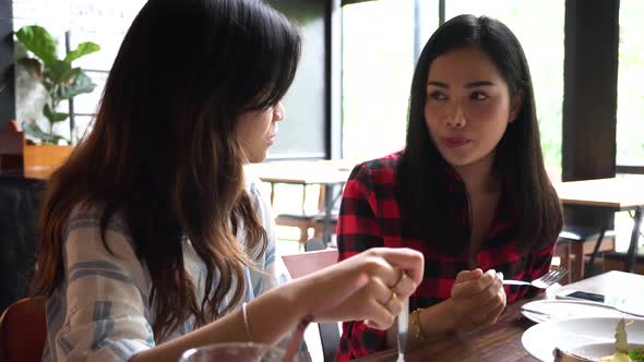 Group of Young Asian Women Eating and Talking at Cafe and Restaurant