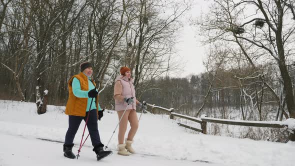 Women Walking with Trekking Poles in Their Hands Outdoors in Winter