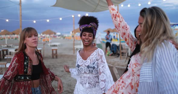 Multiracial female friends having fun dancing together outdoor at beach party