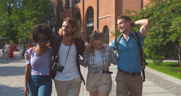 Dolly Shot of Cheerful Multiethnic Travelers Walking in Summer City