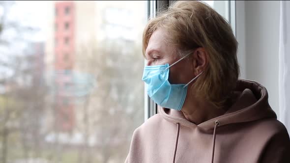 Senior Woman with Medical Mask Near the Window