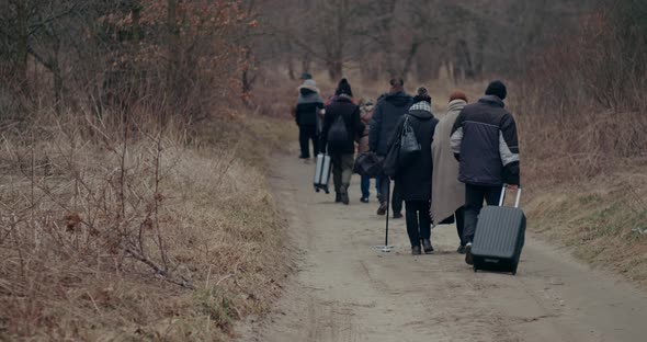 War Refugees With Luggage Walking On Road During Snowfall