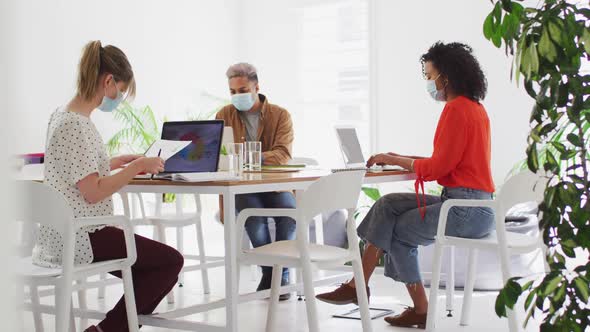 Office colleagues wearing face mask working in office