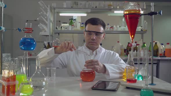 Handsome Professional Scientist Holding Flask in Lab