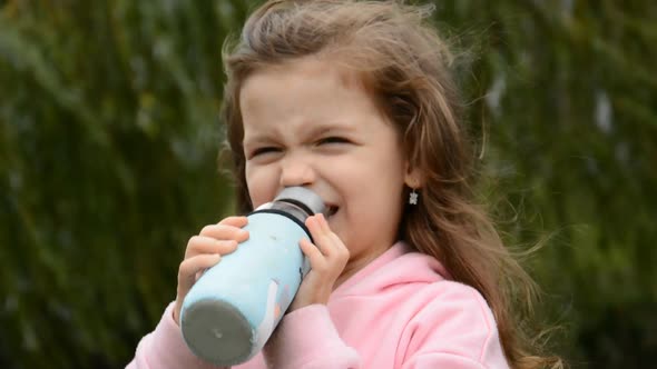 Little Girl Drinking Water From a Bottle