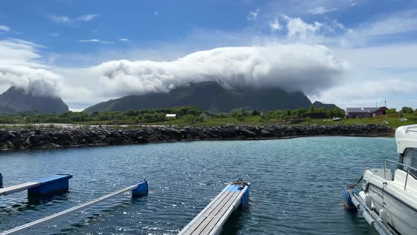 Static shot of a cloud immersion crawling over a mountain in Norway on a nice summer day