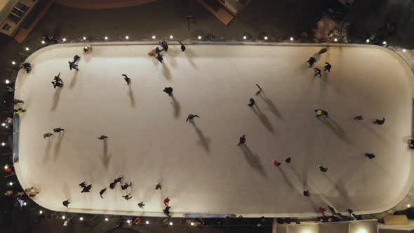 People Are Skating on Ice Rink in the Evening, Aerial Vertical Top-down View