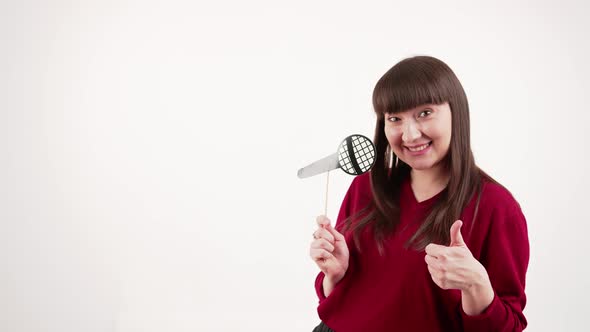 Studio Portrait of Smiley Positive Caucasian Woman in Her 20s Holding Fake Paper Microphone and