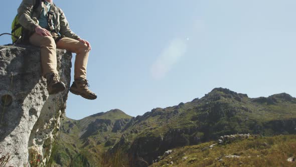 Young Caucasian man sitting on a rock