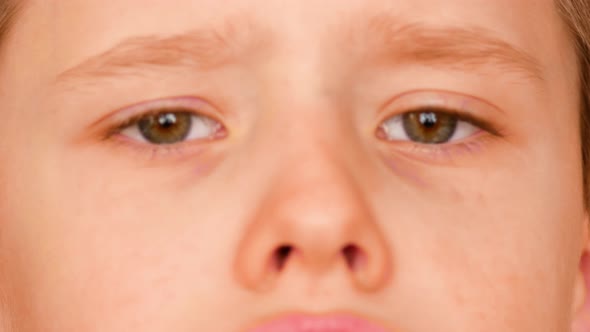 Portrait of a caucasian sad boy 7 years old. Sad eyes of a child close-up.